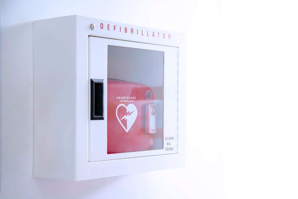 Desfibrilador externo automatizado (AED) en caja blanca en la pared - Para qué sirve